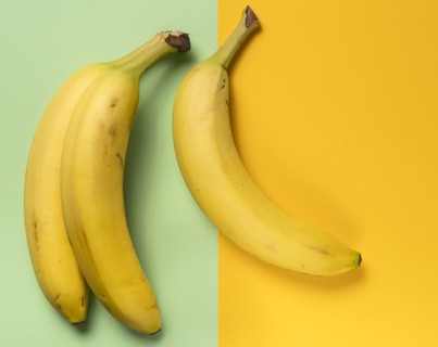 Three ripe bananas on green and yellow background
