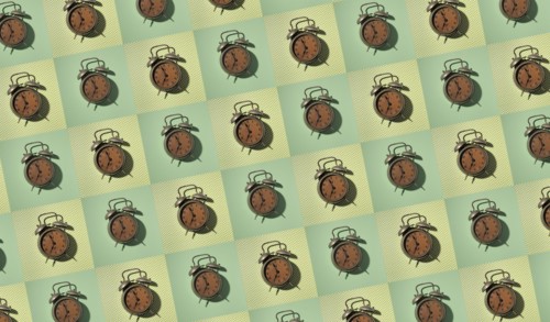 Rows of vintage alarm clocks on green background