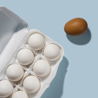 Eggs in carton on blue background