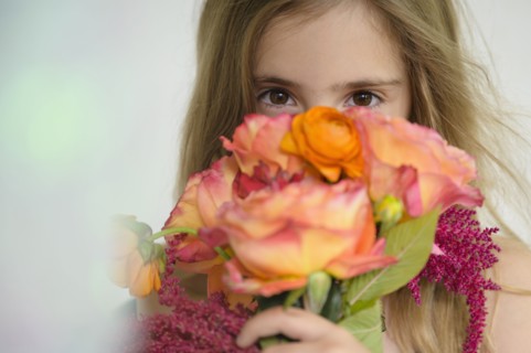 Girl (6-7) holding flower bouquet