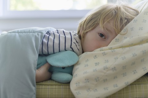 Boy (4-5) lying in bed