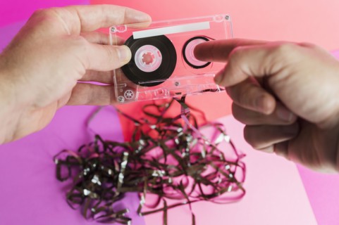 Hands holding damaged audio tape