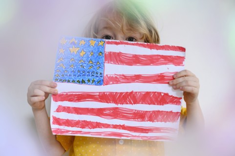 Boy (4-5) showing US flag drawn on paper