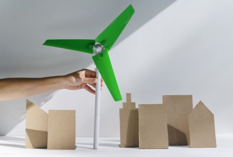 Woman's hand holding scale model of wind turbine
