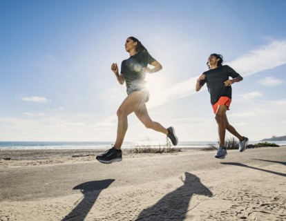 USA, California, Dana Point, Man and woman running together by coastline