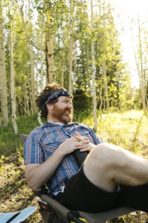 USA, Utah, Uinta National Park, Man relaxing while camping in forest