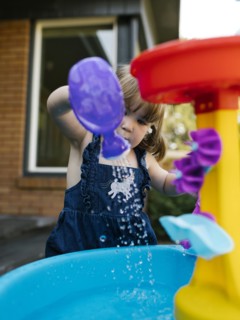 Toddler girl (2-3) playing with water in garden
