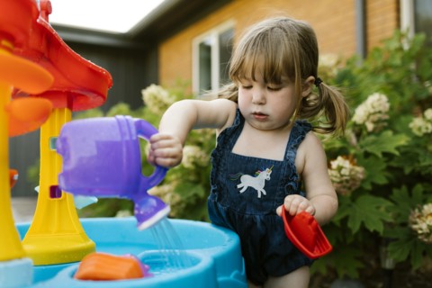 Toddler girl (2-3) playing with water in garden