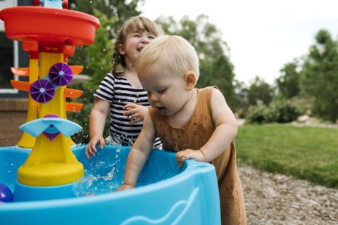 Toddler girl (2-3) and baby boy (18-23 months) playing in garden
