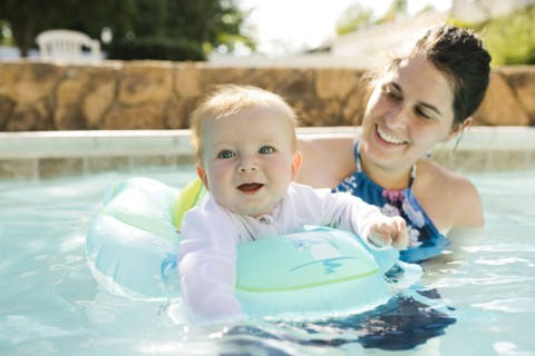 Mother with baby son (6-11months) playing in outdoor swimming pool