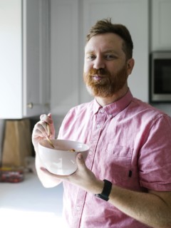 Portrait of man eating cereal breakfast in kitchen
