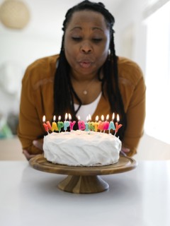Woman blowing candles on birthday cake