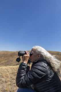 USA, Idaho, Bellevue, Senior woman looking through binoculars in desert