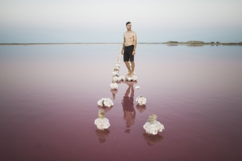 Ukraine, Crimea, Man standing on salt crystal in salt lake