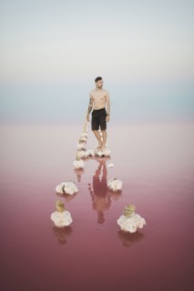 Ukraine, Crimea, Man standing on salt crystal in salt lake