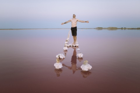 Ukraine, Crimea, Man standing on salt crystal in salt lake