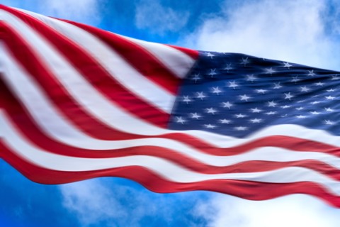 American flag blowing in wind against sky