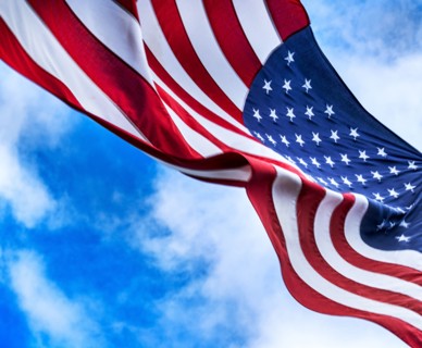 American flag blowing in wind against sky