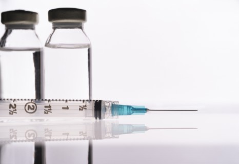 Studio shot of Covid-19 vaccine and syringe
