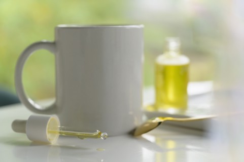 Dropper of CBD oil and mug of tea