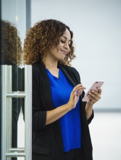 Smiling businesswoman using smart phone in office