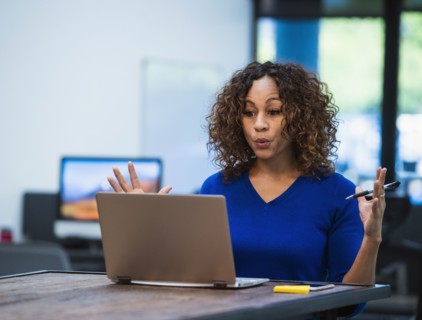 Woman looking at laptop at desk in office