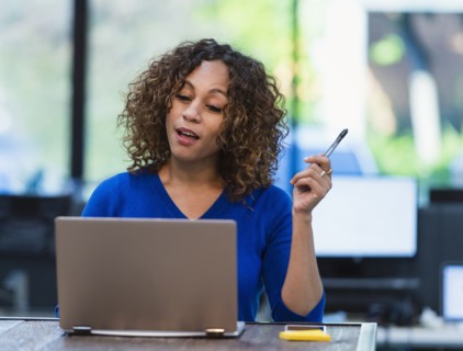 Woman using laptop at desk in office