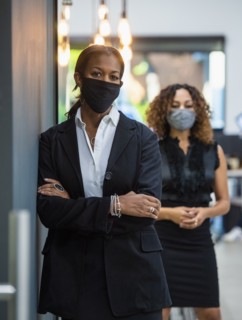 Portrait of businesswomen in face masks standing in office