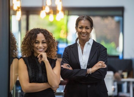 Portrait of two smiling businesswomen standing in office
