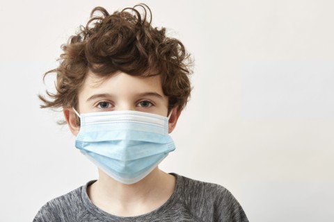 Boy (8-9) wearing protective face mask