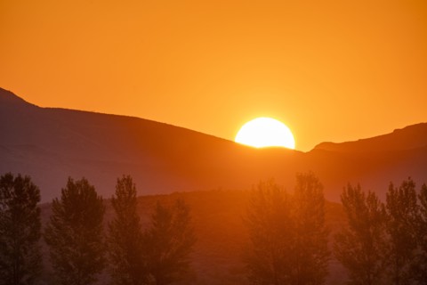 Sun rising behind mountain