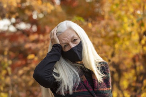 Portrait of senior woman wearing Covid protective mask outdoors in fall