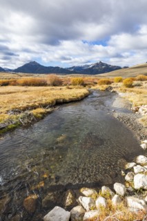 Landscape with stream and mountains in distance