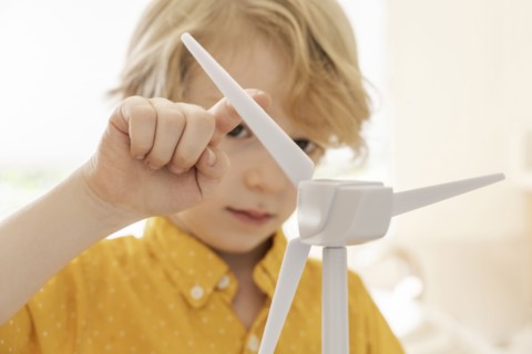 Boy (6-7) playing with wind turbine model
