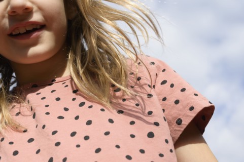 Low angle view of girl (8-9) under cloudy sky