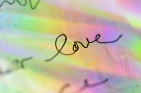 Handwriting on paper with colorful reflections