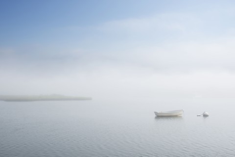 Dinghy on foggy lake
