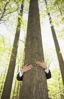 Man in suit hugging tree