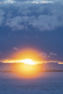 Sun setting over mountains and prairie