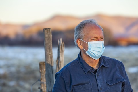 Outdoor portrait of senior man wearing COVID protective mask