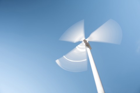 Low angle view of wind turbine against blue sky