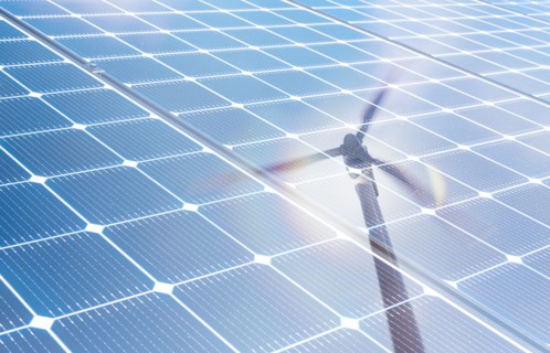 Wind turbine reflected in solar panels