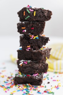 Stack of freshly baked brownies covered with colorful sprinkles