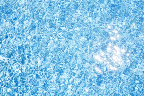 Sparkling reflections of sunlight on pool water surface