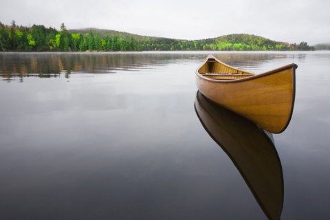 Wooden canoe floating on calm Upper Saranac Lake