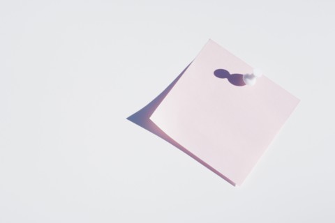 Studio shot of blank pink adhesive post it note
