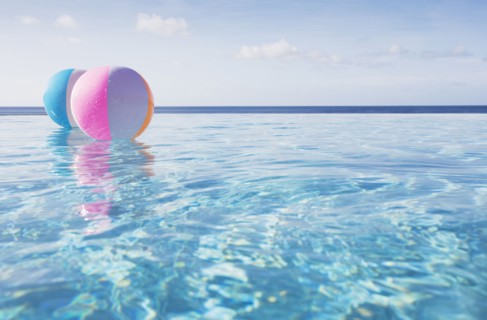 Beach balls floating on water in infinity pool