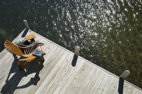 Overhead view of Adirondack chair book and blanket on wooden pier