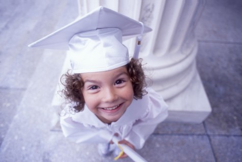 Portrait of girl in white graduation cap and gown