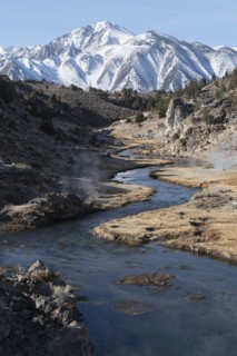 Creek with hot springs with snow covered mountain in background